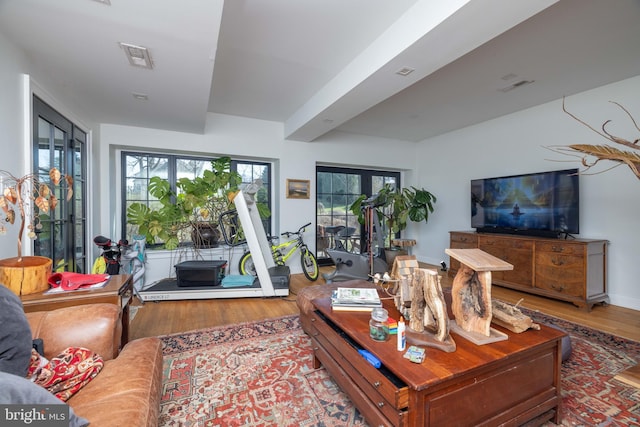 living room featuring wood finished floors, visible vents, and baseboards