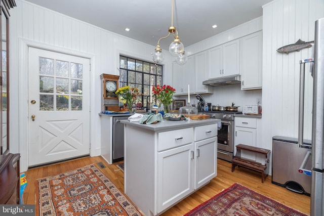 kitchen with under cabinet range hood, stainless steel range, white cabinetry, and light wood-type flooring