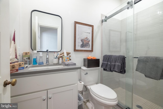 bathroom featuring toilet, a stall shower, and vanity