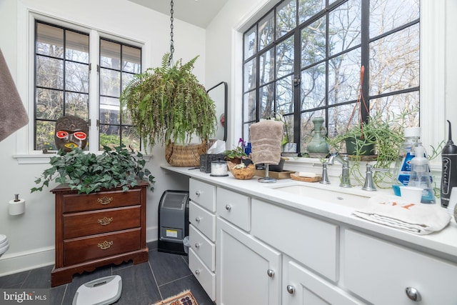 bathroom with tile patterned floors, toilet, a healthy amount of sunlight, and vanity