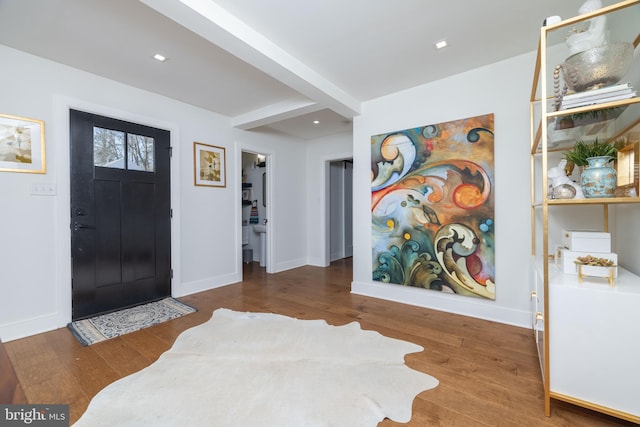 foyer with beam ceiling, recessed lighting, baseboards, and wood finished floors