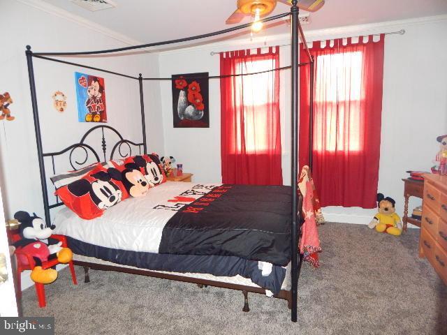 bedroom with crown molding and carpet floors