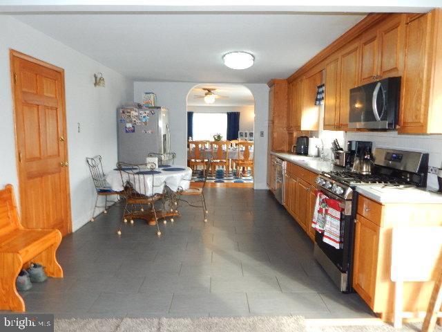 kitchen featuring stainless steel appliances, ceiling fan, and tile patterned floors