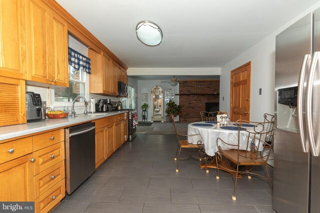 kitchen with ceiling fan, sink, dark tile patterned floors, and stainless steel appliances