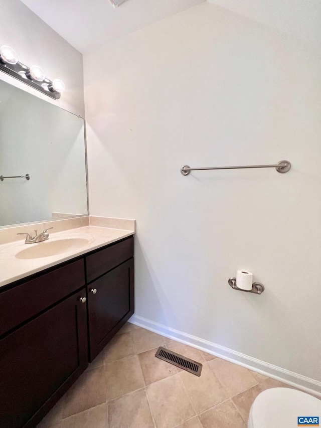 bathroom featuring toilet, vanity, and tile patterned flooring