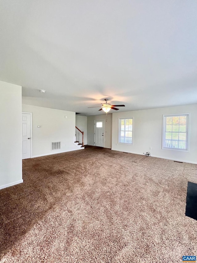 unfurnished living room featuring carpet and ceiling fan