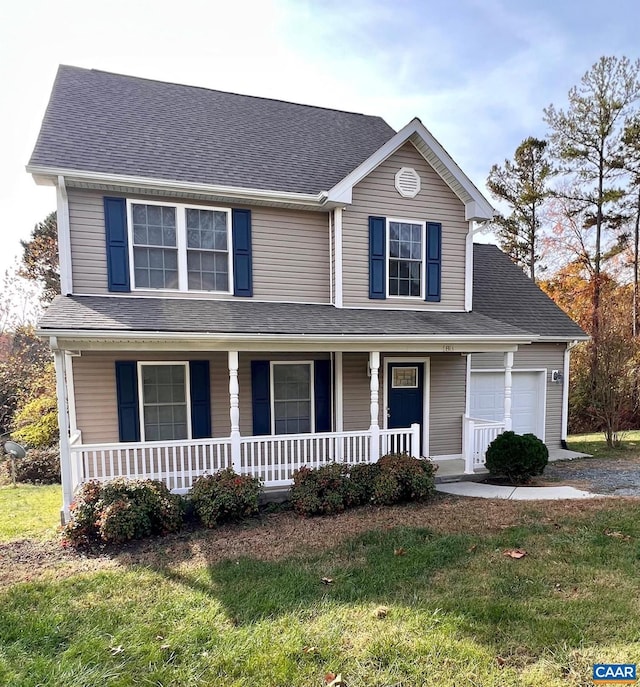 view of front of property with a front yard, covered porch, and a garage