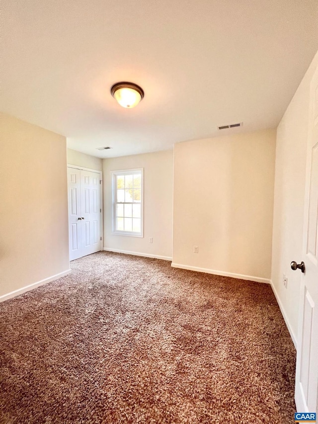 empty room with dark colored carpet