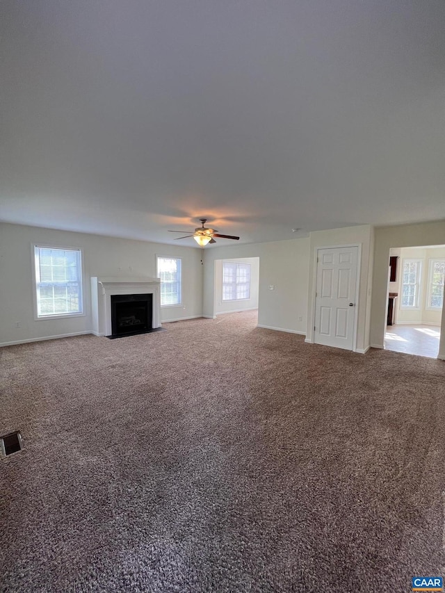 unfurnished living room featuring carpet and ceiling fan