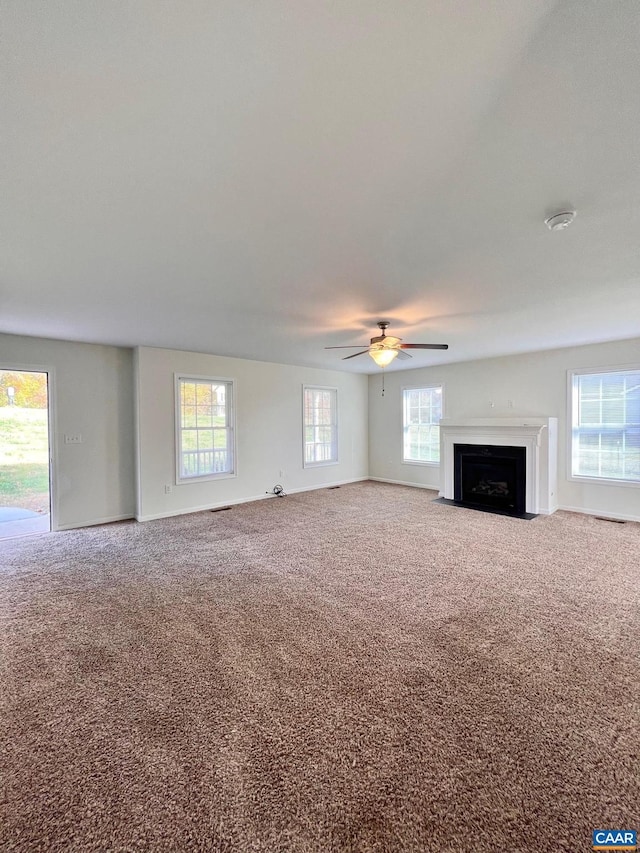 unfurnished living room with carpet and ceiling fan