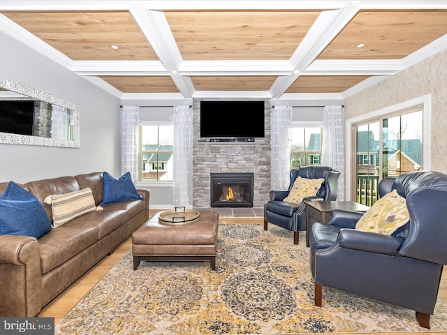 living room with coffered ceiling, light wood-type flooring, crown molding, a fireplace, and wood ceiling