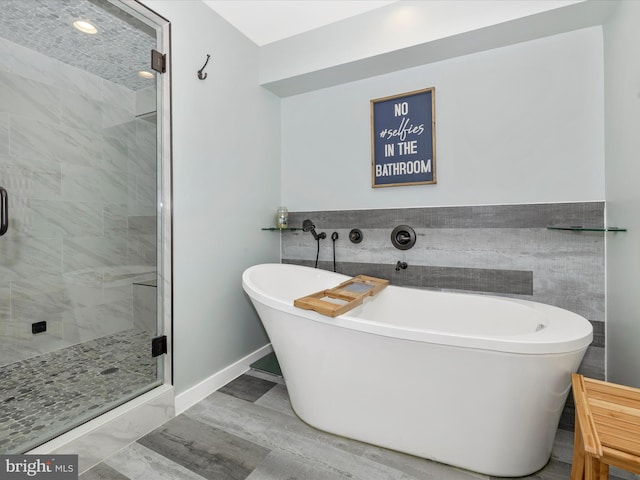 bathroom featuring separate shower and tub and tile walls