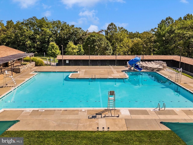 view of swimming pool featuring a patio and a water slide