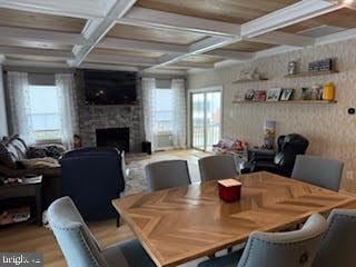 dining room featuring coffered ceiling, wood-type flooring, and beam ceiling