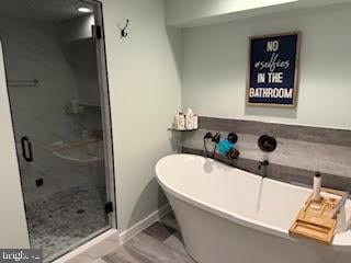 bathroom featuring separate shower and tub