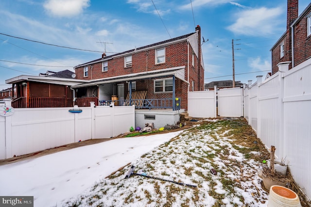 snow covered house featuring covered porch