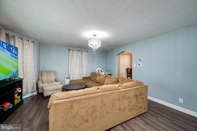 living room with dark hardwood / wood-style floors and a notable chandelier