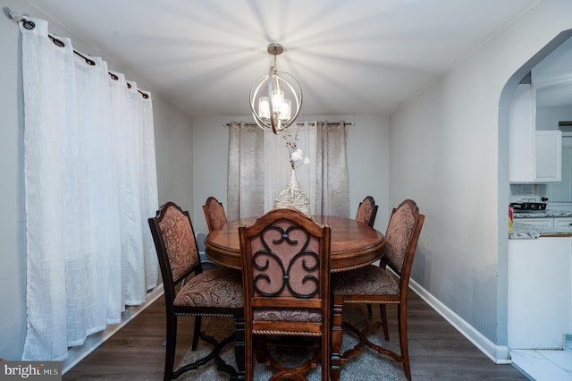 dining space with a notable chandelier and dark hardwood / wood-style flooring