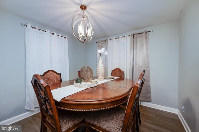 dining room featuring dark wood-type flooring and an inviting chandelier