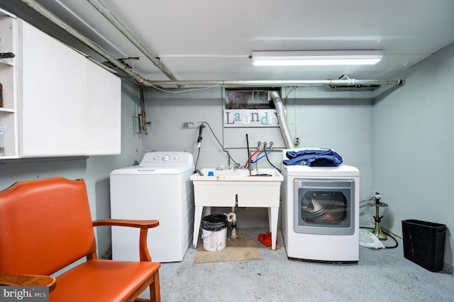 clothes washing area with sink and washing machine and dryer