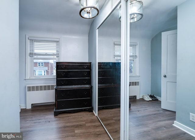 interior space with dark wood-type flooring, radiator, and an inviting chandelier