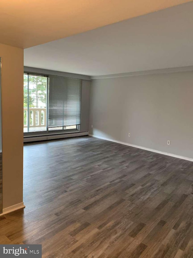 unfurnished room with dark hardwood / wood-style flooring and a baseboard radiator