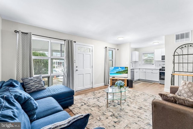 living room featuring plenty of natural light and light hardwood / wood-style flooring