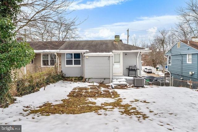 snow covered property with central AC