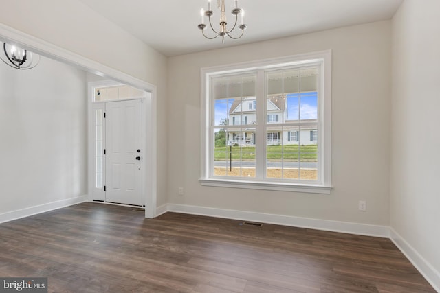 foyer entrance featuring an inviting chandelier and dark hardwood / wood-style flooring