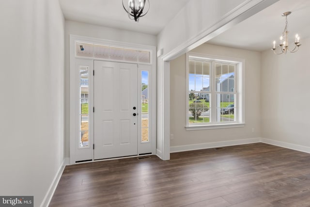 entrance foyer featuring a notable chandelier, plenty of natural light, and dark hardwood / wood-style flooring