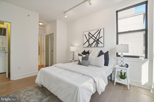 bedroom featuring hardwood / wood-style floors, a closet, and track lighting