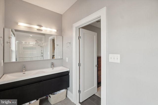 bathroom featuring a shower with shower door and vanity