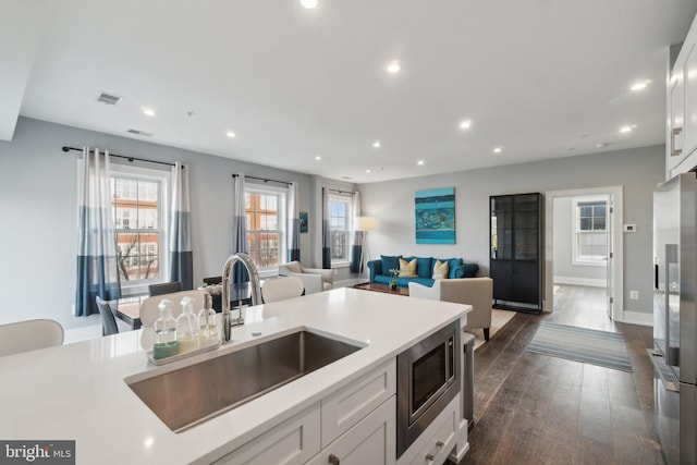 kitchen featuring white cabinets, appliances with stainless steel finishes, dark hardwood / wood-style flooring, and sink