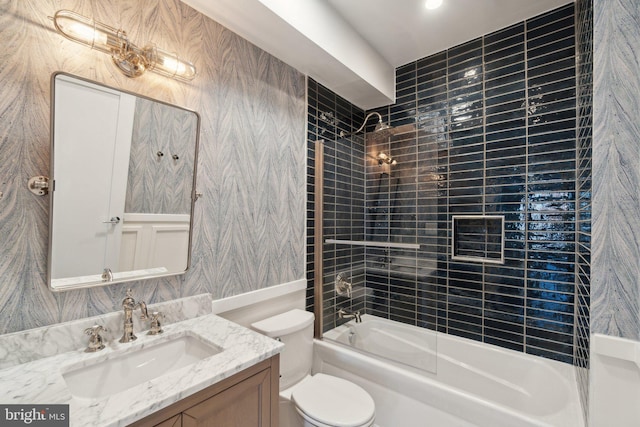 full bathroom with tiled shower / bath combo, vanity, and toilet