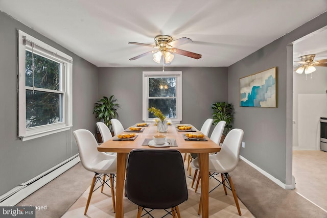 dining area featuring baseboard heating, light colored carpet, and ceiling fan