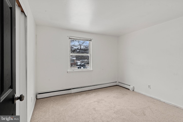 unfurnished room featuring carpet floors and a baseboard heating unit