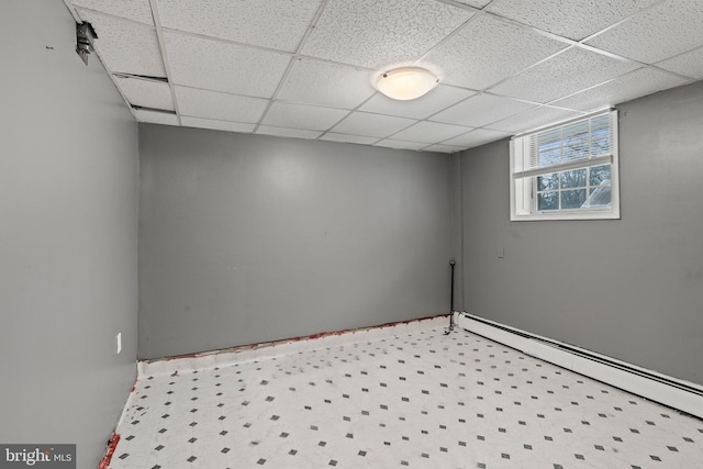 spare room featuring a drop ceiling and a baseboard heating unit