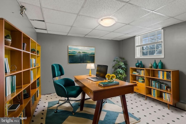 carpeted home office featuring a drop ceiling