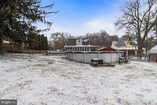 snow covered house featuring a covered pool