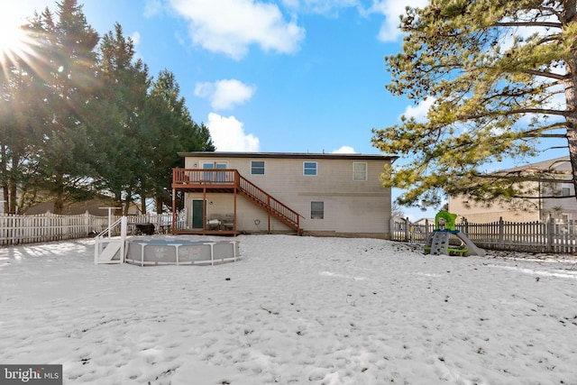 snow covered rear of property with a swimming pool side deck