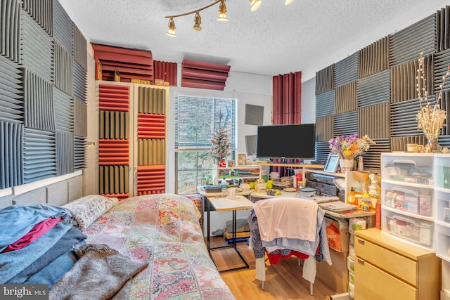 bedroom with a textured ceiling and hardwood / wood-style floors