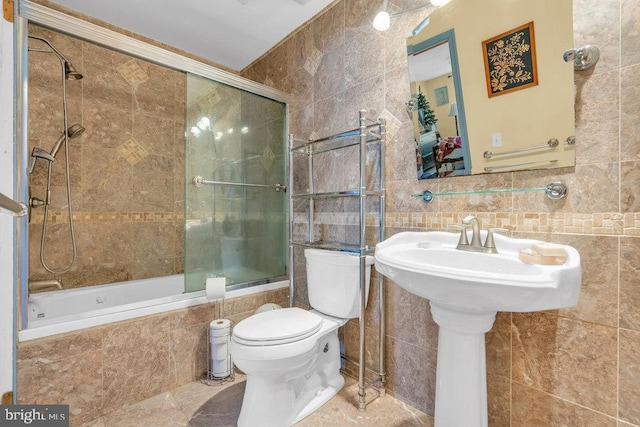 bathroom featuring combined bath / shower with glass door, tile walls, toilet, and tile patterned flooring