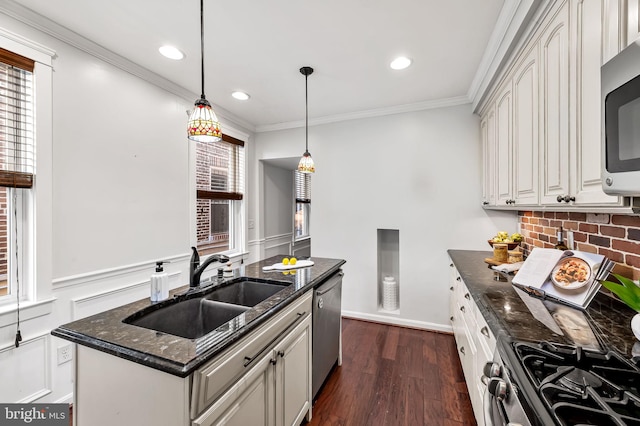 kitchen with pendant lighting, sink, dark stone countertops, stainless steel appliances, and white cabinets