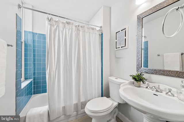 full bathroom featuring sink, shower / bath combination with curtain, and toilet