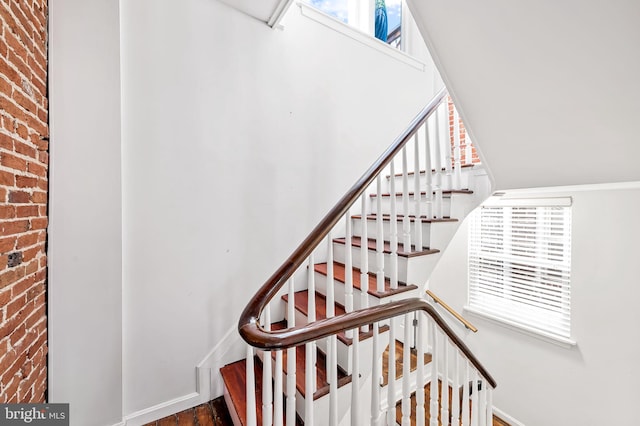 stairs featuring brick wall