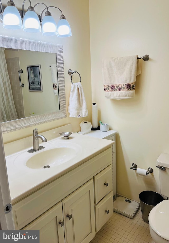 bathroom with toilet, vanity, and tile patterned flooring