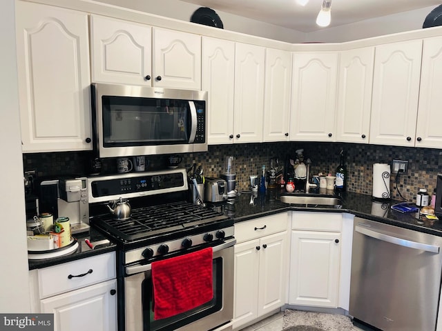 kitchen featuring decorative backsplash, appliances with stainless steel finishes, sink, and white cabinetry