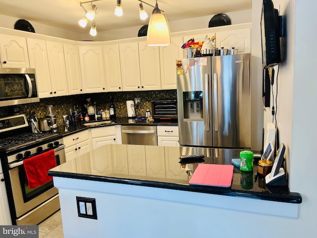 kitchen with pendant lighting, appliances with stainless steel finishes, white cabinetry, backsplash, and light tile patterned floors