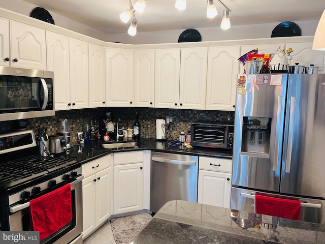 kitchen featuring decorative backsplash, sink, white cabinets, and stainless steel appliances