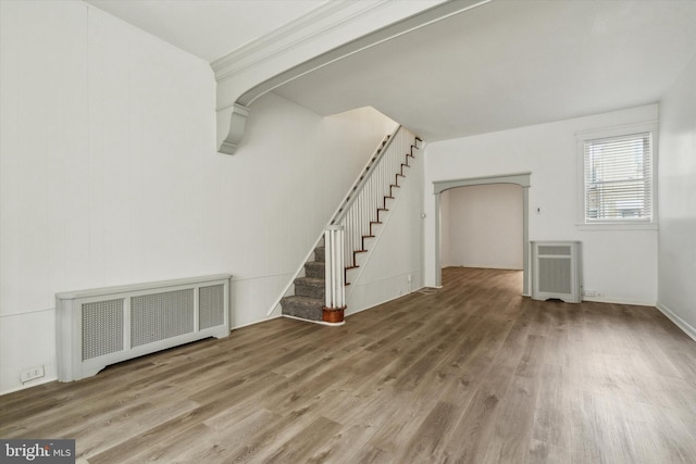 unfurnished living room with wood-type flooring and radiator